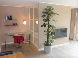 a room with a desk and a chair and a plant at Studio Apartment Elten in Emmerich