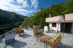 a patio with chairs and tables on a balcony at Perfectstayz Premium Mystic falls with Rooftop Pool & Cafe in Narendranagar