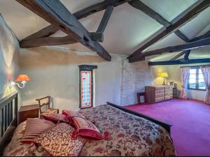 Un dormitorio con una cama grande y una ventana. en Maison La Cloche, en Fourcès