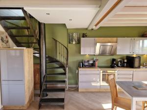 une cuisine avec un escalier en colimaçon dans une pièce dans l'établissement Cottage La Grenouillère, à Menetou-Râtel 8 autres photos