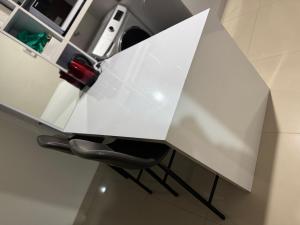 a white desk with a black chair underneath it at Apartemen Embarcadero in Pondokpucung +9 photos