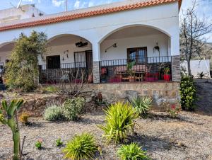a house with arches and plants in the yard at El Cortijo Escondido Ohanes in Ohanes