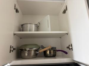 a kitchen with some pots and pans on shelves at Apartemen Embarcadero in Pondokpucung