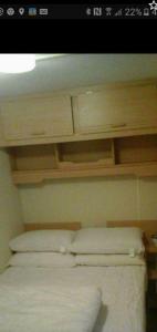 - une chambre avec 2 oreillers au-dessus d'un lit dans l'établissement Mv16 4 bed caravan on the Golden Palm, à Chapel St. Leonards 3 autres photos