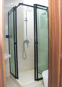 una ducha con puerta de cristal en un baño en Yah Dafi Apartment, en Abuja