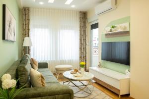 a living room with a couch and a tv at Cherry Lux Apartments in Arandelovac