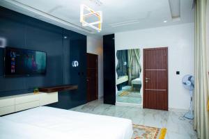 a bedroom with a bed and a blue wall at Yah Dafi Apartment in Abuja +9 photos