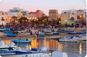 a group of boats on the shore of a harbor at A 100 passi dal mare in Bari +19 photos