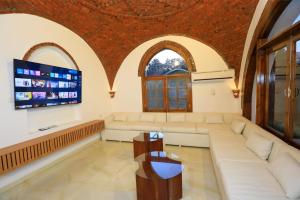 a living room with a couch and a flat screen tv at Desert Rose apartment's in Luxor
