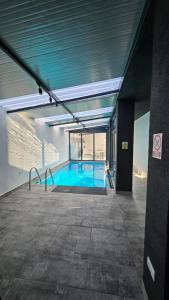 a large swimming pool in a building with a building at Casa Mathias in Eforie Nord