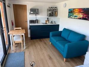 a living room with a blue couch and a kitchen at The Loch Cabin in Fort William +19 photos