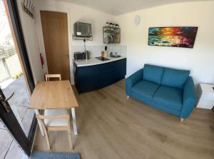 a living room with a blue couch and a table at The Loch Cabin in Fort William
