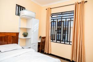 a bedroom with a bed and a window at Pundamilia Private rooms in Kikuyu