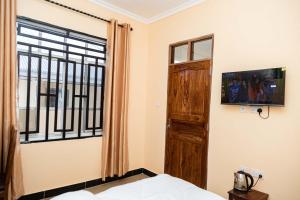 a room with a bed and a window and a door at Pundamilia Private rooms in Kikuyu