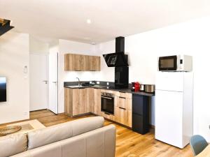 a living room with a couch and a kitchen at Appartement 3 chambres in Montceau-les-Mines +22 photos