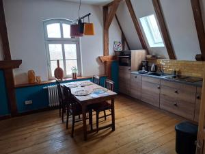 a kitchen with a table and chairs in a room at Schlossbahnhof Ballenstedt in Ballenstedt