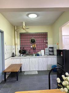 a kitchen with a sink and a table in it at Seri Laguna Homestay in Port Dickson