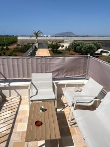 due sedie bianche e un tavolo sul tetto di Nausicaa Guesthouse a Marsala