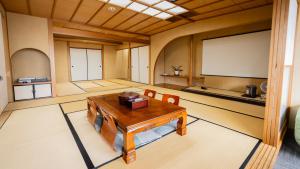 Habitación grande con mesa y pantalla. en 熱海の隠れ里, en Atami