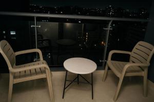 two chairs and a table on a balcony with a view at Riara One Residency, Kilimani in Nairobi