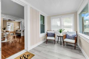 ein Wohnzimmer mit Stühlen und einem Tisch und Fenstern in der Unterkunft Bungalow Blue in Bradley Park in Neptune City