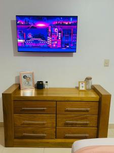 a wooden dresser with a tv on a wall at Brisas de las Montañas in Jarabacoa