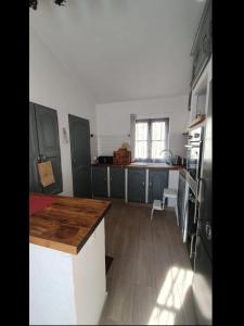 a kitchen with blue cabinets and a wooden counter top at La Sudagna in Peillon