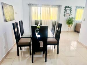 a dining room with a black table and chairs at Brisas de las Montañas in Jarabacoa