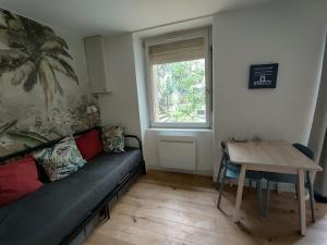 波尔多Appartement rénové 1 chambre centre historique的客厅里有一张沙发和一张桌子。