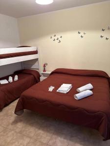 Un dormitorio con dos camas con toallas y pájaros en la pared. en Claudia B&B, en Pescasseroli