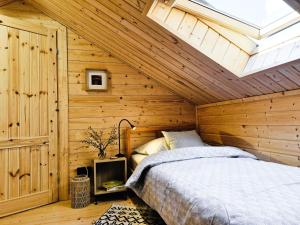 a bedroom with a bed in a wooden wall at Sosny i Róże in Domysłów