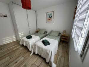 two beds in a room with white walls and wooden floors at Villa Océane in Mimizan-Plage +9 photos