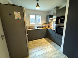 a kitchen with a refrigerator and a wooden floor at Villa Océane in Mimizan-Plage
