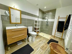 a bathroom with a sink and a toilet and a mirror at Villa Océane in Mimizan-Plage