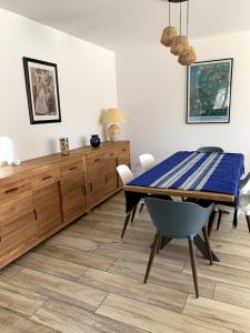 a dining room with a blue table and chairs at Villa Océane in Mimizan-Plage