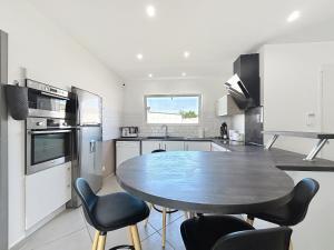 a kitchen with a table and chairs in it at Villa Grivia - Maison avec grand jardin - Piscine - Pétanque - Ping Pong in Saint-André-de-Roquelongue