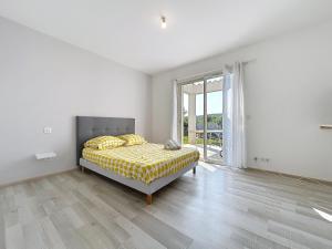 a white bedroom with a bed and a large window at Villa Grivia - Maison avec grand jardin - Piscine - Pétanque - Ping Pong in Saint-André-de-Roquelongue +18 photos