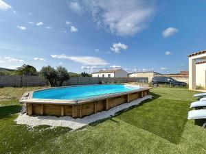 a large swimming pool in a yard with a car at Villa Grivia - Maison avec grand jardin - Piscine - Pétanque - Ping Pong in Saint-André-de-Roquelongue