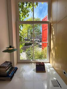 een raam in een kamer met een boek op een tafel bij LE GARAGE Downtown serviced apartment in Den Haag