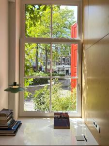 een raam in een kamer met een boek op een tafel bij LE GARAGE Downtown serviced apartment in Den Haag