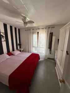 une chambre avec un lit avec une couverture rouge dans l'établissement Aloha Corralejo, à Corralejo