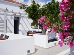 a white house with pink flowers in the foreground at The Mill in Karpathos Town