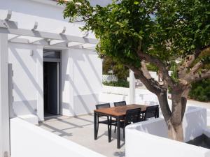 a wooden table and chairs next to a tree at The Mill in Karpathos Town