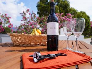 a bottle of wine sitting on a table with two glasses at The Mill in Karpathos Town +21 photos