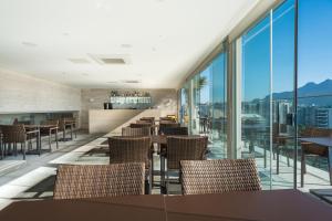 a restaurant with tables and chairs and large windows at Windsor Marapendi Hotel in Rio de Janeiro