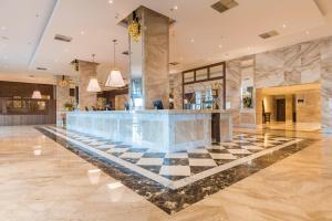 a lobby with a checkered floor and a bar at Windsor Marapendi Hotel in Rio de Janeiro