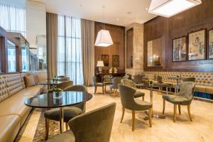 a restaurant with tables and chairs and a couch at Windsor Marapendi Hotel in Rio de Janeiro