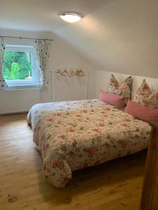 a bedroom with a bed with a comforter and a window at Ferienwohnung Schatzkisterl in Wörth +28 photos