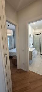 Un baño blanco con lavabo y cama. en Le Case di Giò - Monza Centro a 200 mt Arengario, Parco, Zucchi, en Monza