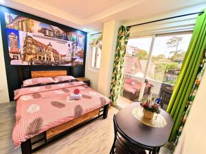 a bedroom with a bed and a table and a window at #3 Baguio City I Service Apartment I Deutsches Guesthouse & Homestay Baguio I Walking distance to Lourdes Grotto and nearby tourist attractions in Baguio
